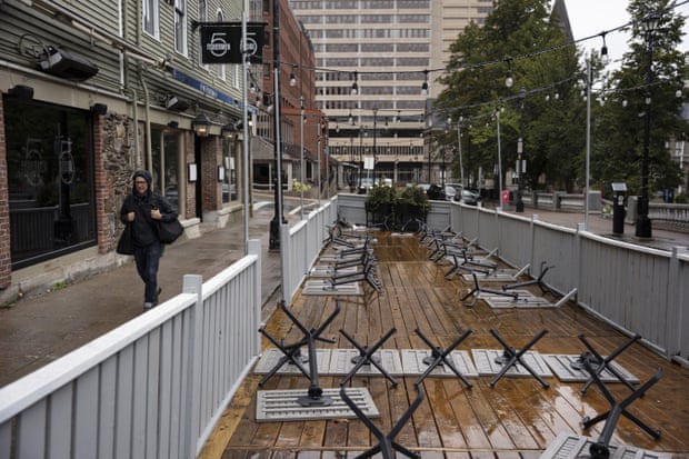 person walks by tables on patio