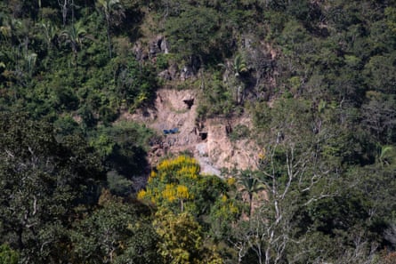 Large holes in an area of cleared ground surrounded by trees and vegetation