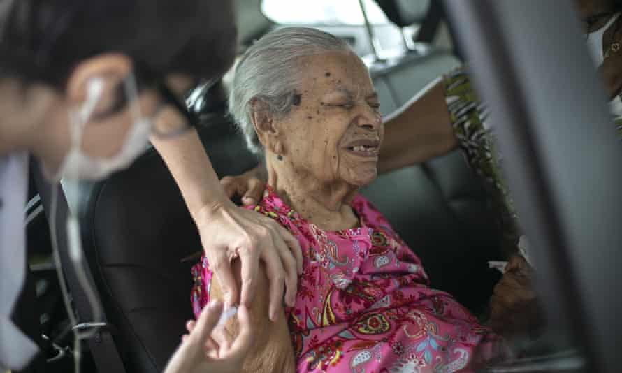 Maria de Lourdes, 101, receives a dose of China’s Sinovac Biotech COVID-19 vaccine at a drive-through vaccination site in the Sambadrome, in Rio de Janeiro, Brazil.