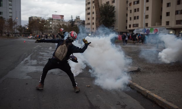 A demonstrator clashes with security forces during a protest amid the coronavirus pandemic in Santiago on 27 April.