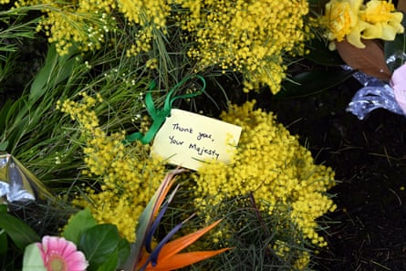 Flowers and messages about the Queen seen under a tree at Government House in Canberra