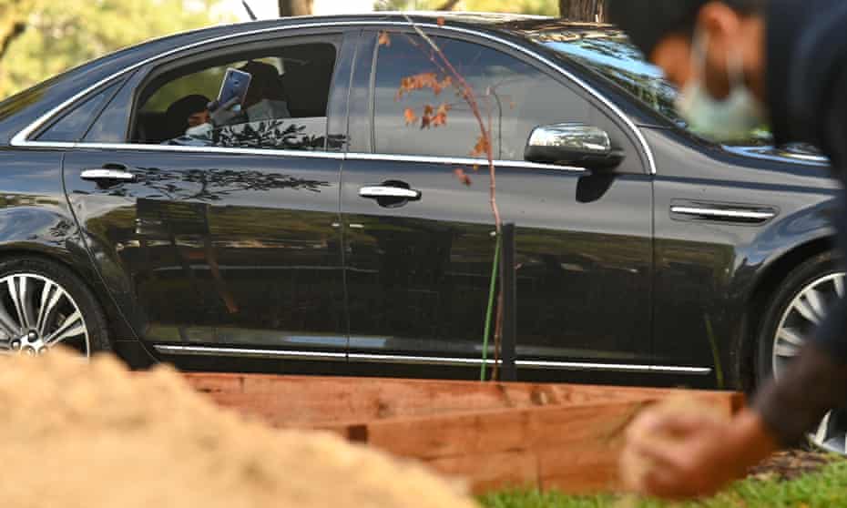 Parents watch burial from car