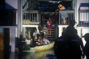 people walk down stairs to a raft to be rescued