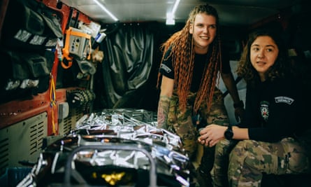 Tetiana Romaniuk and Olha Danyliuk in the back of a makeshift ambulance with a patient trolley
