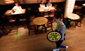 A waitress serves pizza at a restaurant in Moscow