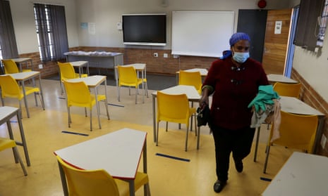 A worker walks past safely spaced desks following safe distancing measures amid the spread of the coronavirus disease outbreak at the Seshegong secondary school in Olivenhoutbosch, South Africa, May 28, 2020.