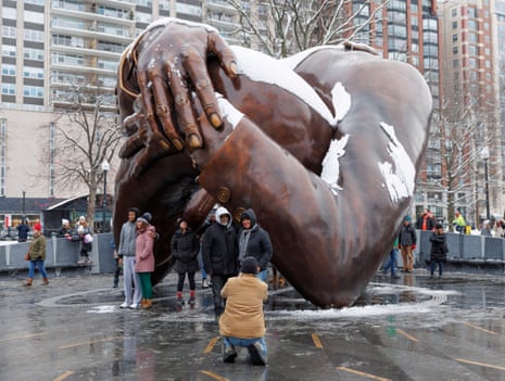People pose at the Martin Luther King Jr memorial statue The Embrace on Martin Luther King Jr Day on the Boston Common in Boston.