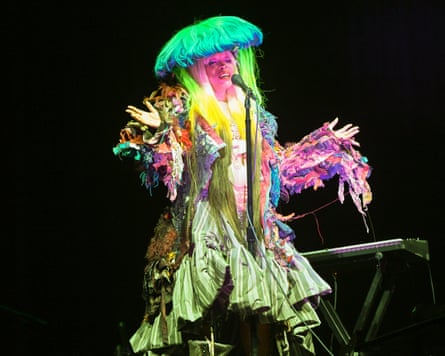 Erykah Badu performing onstage, dressed like a jellyfish