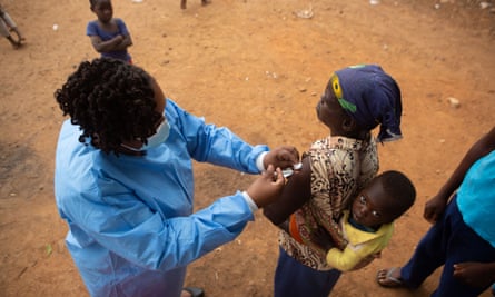 A woman gets vaccinated with an infant on her back in Chinhoyi, Zimbabwe