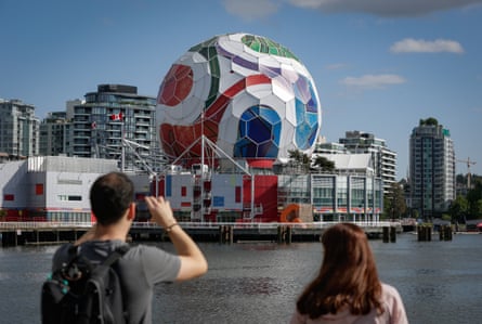 A man takes photos of the dome of Science World as it is being transformed into a giant official match ball of the Fifa World Cup 2026 ahead of the tournament in Vancouver