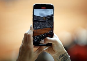 A spectator takes a picture, using a smartphone, of Aryna Sabalenka in action against Coco Gauff in the women’s final