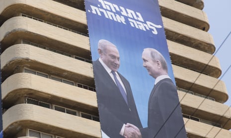 Τεράστια διαφημιστική πινακίδα του κόμματος Likud που τρέχει κάτω από ένα τετράγωνο πύργου δείχνει μια εικόνα του Μπενιαμίν Νετανιάχου να χαιρετάει τον Βλαντιμίρ Πούτιν με μια χειραψία