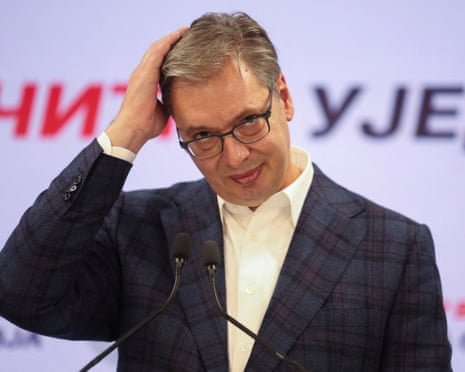 Aleksandar Vucic runs his hand through his hair at microphones after election results
