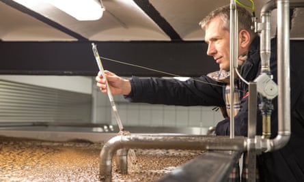 Stefan Fritsche checks the temperature of a vat of fermenting hops.