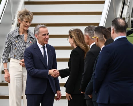 Carney and his wife are greeted at Sydney airport ahead of his four-day visit to Australia.