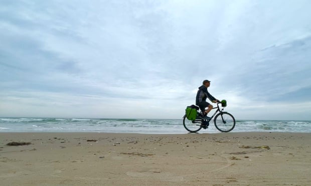 Kevin Rushby cycles along beach near Thorup Strand.