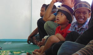 Kyhon Price (red shirt in center) at the only Muslim Ahmadiyya Mosque in the Marshall Islands on Majuro Atoll. His mother was the victim of a human trafficking scheme led by US citizen Paul Petersen that saw pregnant women from the Marshall Islands trafficked to the United States and their babies given up for adoption. Kyhon's father, Rolson Price, is on the far left. He has never met his daughter, who he says was put up for adoption without his permission.