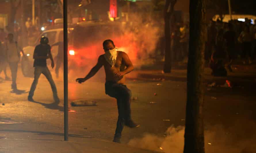 A protester kicks a tear gas canister during Sunday’s clashes.