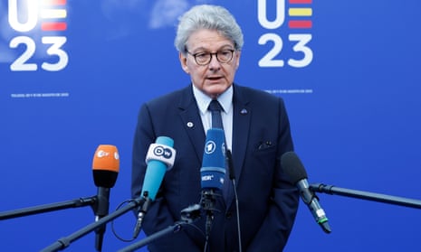 Thierry Breton stands in front of four microphones