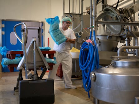 Patrick Pourny holds a blue bag filled with cheese at a factory in France