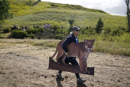Amy Silver, voluntaria de la Federación Nacional de Vida Silvestre, lleva un recorte de cartón de un león de montaña durante una ceremonia de inauguración del Wallis Annenberg Wildlife Crossing en Agoura Hills, California, en abril.