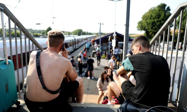 Stranded rail passengers wait at Alnmouth station on Monday after to track failure caused by the heatwave.