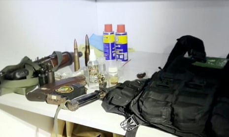 A bulletproof vest with Hamas insignia sits on a table with other weaponry