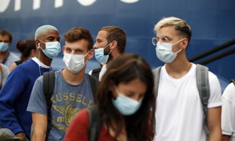 People wearing a face masks to prevent the spread of coronavirus wait to board a ferry in the port of Piraeus, near Athens.