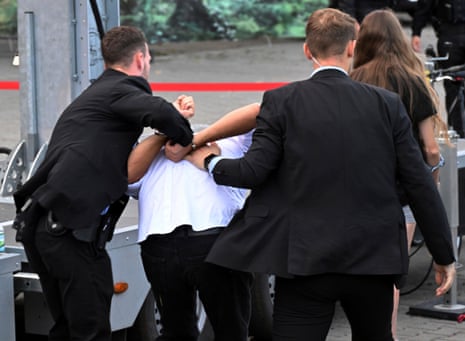 Guardaespaldas se llevan a un hombre que presuntamente llevó a cabo un ataque con pintura roja en un evento de campaña electoral organizado por la Alianza Sahra Wagenknecht (BSW) en la Plaza de la Catedral, en Erfurt, Alemania, el jueves 29 de agosto de 2024.