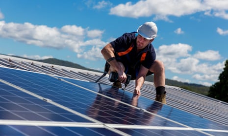 Man installing solar panels on a roof on a sunny day