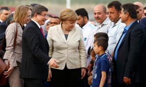 Turkish prime minister Ahmet Davutoglu and Angela Merkel speak to children in Nizip refugee camp at the weekend