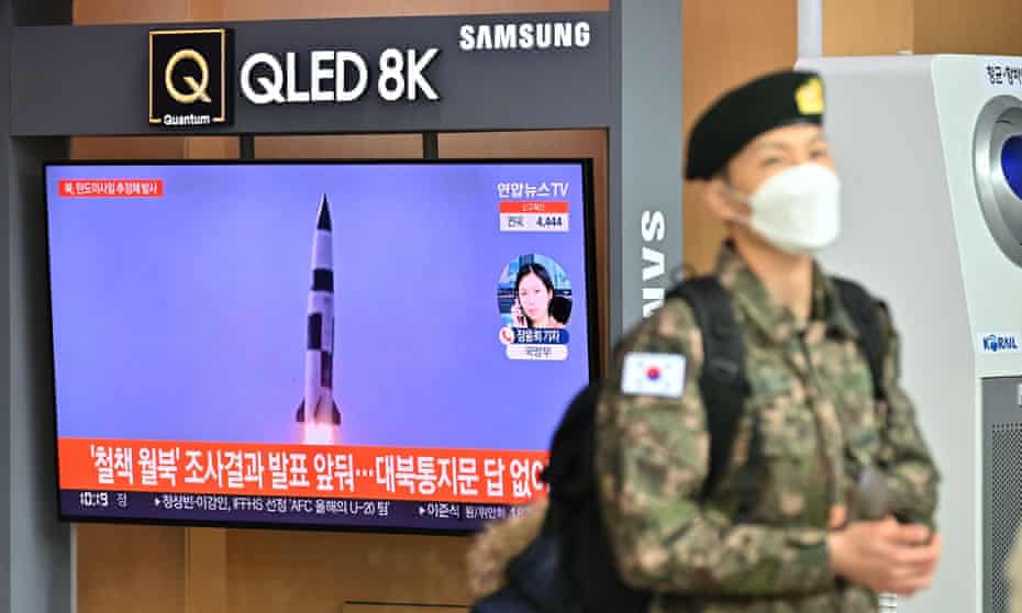 A South Korean soldier walks past a television news screen showing file footage of a North Korean missile test in Seoul after North Korea fired what appeared to be a ballistic missile into the sea off its east coast according to the South's military.  