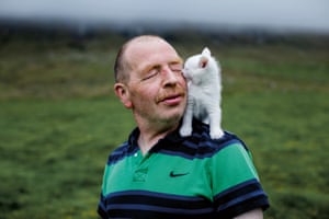 Andrias (54) with his little white pet kitten outside his home, which he shares with his mother in Vidareidi. As a young man, Andrias went to Denmark to study to become a teacher, because his mother forbade him to go fishing. But after a few years he came home and bought his own boat.