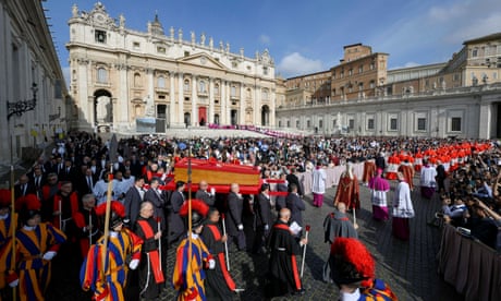 O corpo do Papa Francisco é carregado em um caixão pela Praça de São Pedro; o cortejo é escoltado por guardas do Vaticano em trajes tradicionais vermelhos, azuis e dourados e cardeais em vermelho e branco; uma grande multidão fica atrás.
