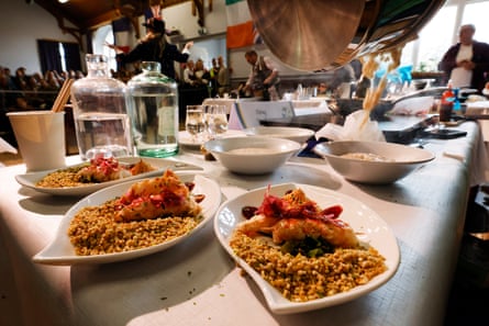 White, boat-shaped dishes of porridge with langoustine on top are placed on a long table