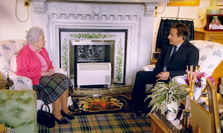 The Queen and David Cameron chat next to the thistle-tiled fireplace