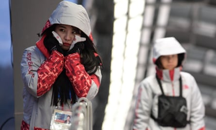 A volunteer uses handwarmers at the Winter Olympics