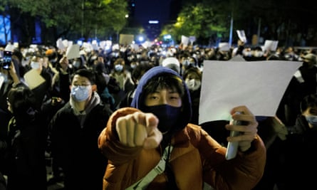 people hold white sheets of paper at a  demonstration against Covid restrictions 