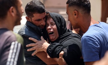 Palestinians mourning at Al-Aqsa Martyr's Hospital in Deir al-Balah, Gaza.