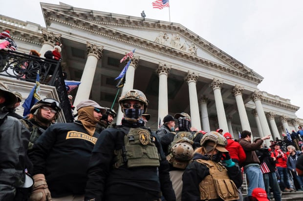 Members of the Oath Keepers militia group stand among supporters of Trump at the east front steps of the US Capitol.