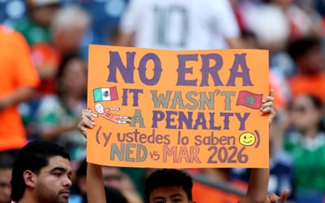 A fan holds a sign that says "No Era It Wasn't a Penalty (y ustedes lo saben)" at Estadio Monterrey.