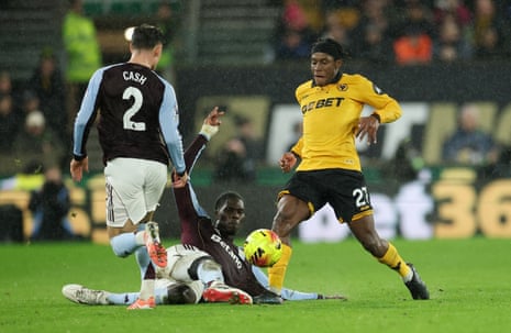 PreJean-Ricner Bellegarde is tackled by Amadou Onana and Matty Cash as the rain continues to pour down in the West Midlands.