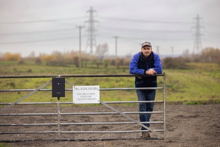 Farmer Nick Hill leaning on a gate on his land in Lincolnshire, UK, which will be affected by a proposed solar farm