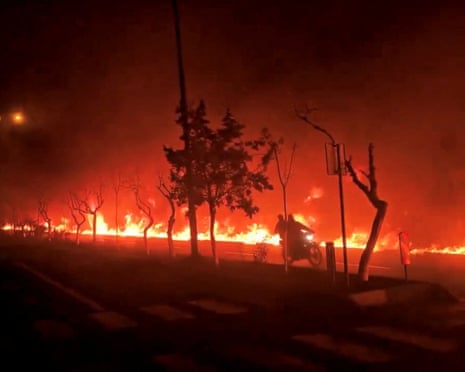 A motorcycle passes by fire burning along Tehran’s Koohsar Boulevard, in an image from video on social media released on Sunday