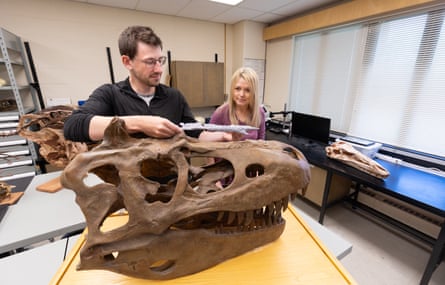 a man and a woman with a dinosaur skull