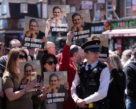 Protesters hold signs reading “Keir Starmer, Jew harmer”
