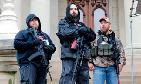 Armed protesters take part in rally on 30 April at the Michigan state capitol in Lansing, demanding the reopening of businesses shut as an anti-coronavirus measure.