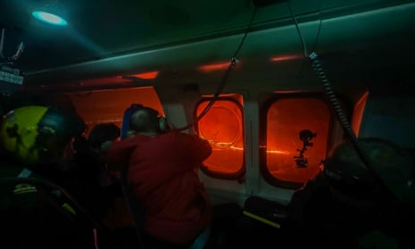 Scientists observe the smoke and lava turning the sky orange are seen in this Icelandic Coast Guard handout image flying over an volcanic eruption on the Reykjanes peninsula 3km north of Grindavik, western Iceland.