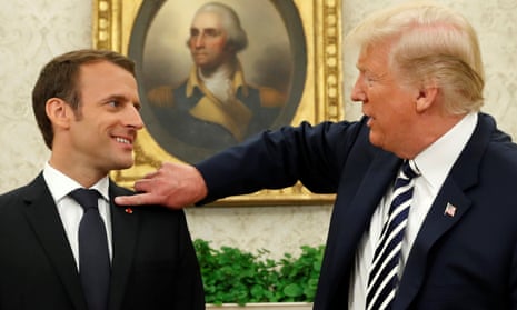 Donald Trump flicks a bit of dandruff off Emmanuel Macron’s jacket.