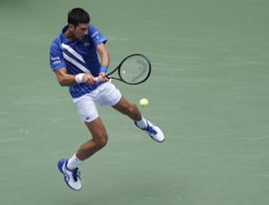 A leaping Novak Djokovic hits a return.